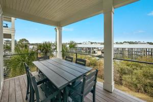 porche con mesa de madera y sillas en la cubierta en Feels Like Home at The Osprey, en Orange Beach