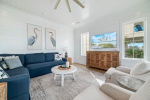 Una sala de estar con un sofá azul y dos sillas. en Feels Like Home at The Osprey, en Orange Beach