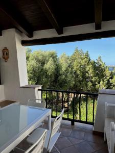 a white table and chairs on a balcony with a view at Corte dei Mori 239 in Liscia di Vacca +29 photos