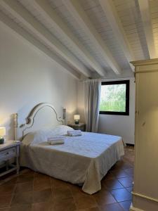 a bedroom with a bed and a window at Corte dei Mori 239 in Liscia di Vacca