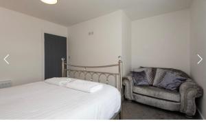 a bedroom with a bed and a chair at Nelson 2 Double bedrooms 1 bathroom in Crook