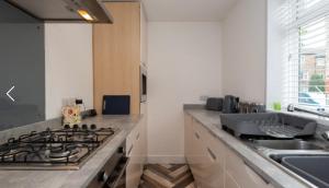 a kitchen with a stove top oven next to a sink at Nelson 2 Double bedrooms 1 bathroom in Crook +2 photos