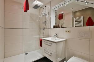 a white bathroom with a sink and a mirror at Gästehaus Alexandra in Ramsau