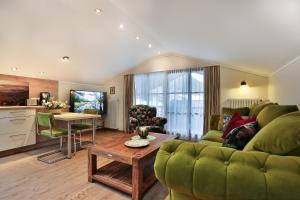 a living room with a green couch and a table at Gästehaus Alexandra in Ramsau