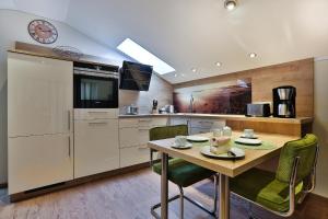 a kitchen with a table and chairs and a clock at Gästehaus Alexandra in Ramsau +29 photos