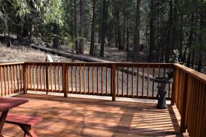 a wooden deck with a bird feeder and a picnic table at Sequoia House at The Redwoods in Wawona