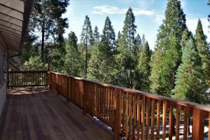 a deck with a view of the trees at Sequoia House at The Redwoods in Wawona