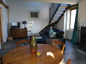 a living room with a wooden table and a couch at Gîte La Bouchonnette in Savigny-sur-Grosne