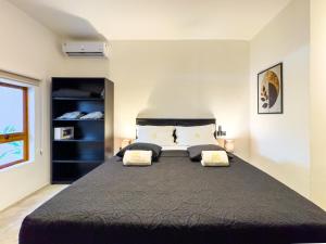 a bedroom with a large bed with two pillows at Pousada Praia do Carioca Búzios in Búzios