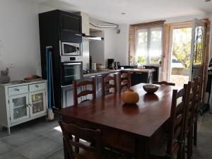 a kitchen with a wooden table and a dining room at Gîte La Bouchonnette in Savigny-sur-Grosne