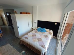 Depto España Mdq في مار ديل بلاتا: غرفة نوم صغيرة مع سرير وخزانة