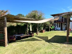 a patio with a canopy and a picnic table in a yard at Cabaña Luna Rubia in La Pedrera