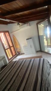 een slaapkamer met een bed en een surfplank aan de muur bij Suíte Quarto Amplo - Sul da Ilha in Florianópolis