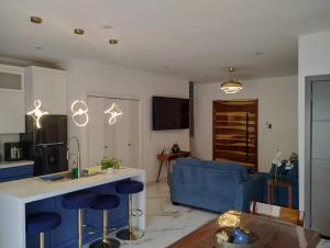 Il comprend une cuisine et un salon doté d'un canapé bleu. dans l'établissement Casa Brianna Vacacional - Alberca Privada, à Puerto Peñasco