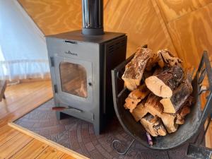 a wood stove with a bowl of bread in it at Bóreas Ecoluxury Glamping in El Calafate
