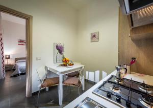 kuchnia ze stołem, krzesłami i kuchenką w obiekcie Casa Marte w mieście Castellammare del Golfo