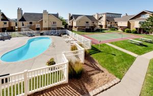 un patio trasero con pista de tenis y raqueta de tenis en Hawthorn Suites Wichita East, en Wichita