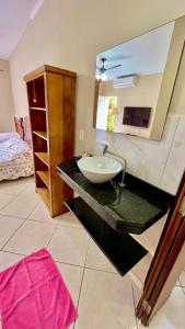La salle de bains est pourvue d'un comptoir avec un lavabo et un miroir. dans l'établissement Na Boca do Jacaré, à Caraguatatuba 43 autres photos
