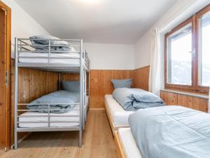 a bedroom with two bunk beds and a window at Sonnenhütte in Niederau