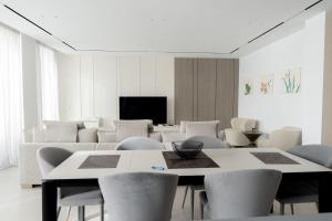 a room with chairs and a table and a tv at Crystal Beach Radhime in Vlorë