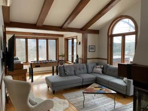 a living room with a couch and a table at Lake views, spa, king bed, Golf Club amenities in Mont-Blanc