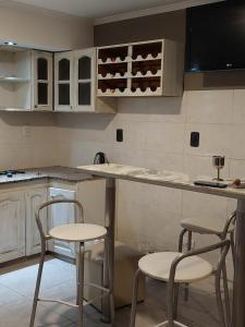 a kitchen with two chairs and a counter with wine bottles at Casa cerca de la playa in Mar del Plata