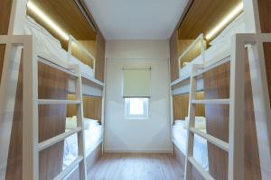 a room with four bunk beds and a window at Dreambox Malacca in Melaka