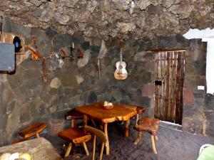 una stanza con un tavolo e una chitarra appesa a un muro di Casa Guinea a Frontera