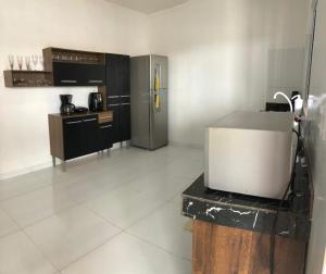 a kitchen with a refrigerator and a table in it at Espaço Brisa do sertão in Piranhas +3 photos