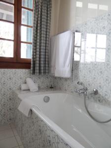 a white bath tub in a bathroom with a window at Auberge Des Chasseurs in Échenevex