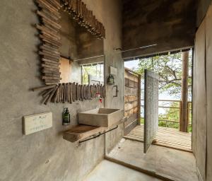 een betonnen badkamer met een wastafel en een raam bij CasaCoral Hotel in Puerto Limón +84 foto's