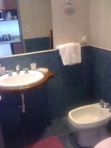 a bathroom with a sink and a toilet and a mirror at Tu Lugar en Salta in Salta