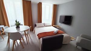 a room with a bed and a table and a tv at Holiday week-end mercurey in Mercurey