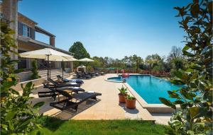 - une piscine avec des chaises et des parasols à côté d'un bâtiment dans l'établissement Villa Nikolina, à Poreč