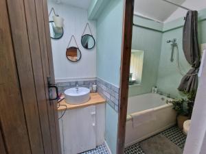 a bathroom with a sink and a bath tub at Quarry Cottage in Blaenau-Ffestiniog +14 photos
