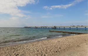 a sandy beach with a pier in the water at Lovely Apartment In Graal-Müritz in Graal-Müritz