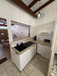 eine Küche mit Spüle und Mikrowelle in der Unterkunft Studio 104 - Centre ville et plage de Sainte-Anne in Sainte-Anne