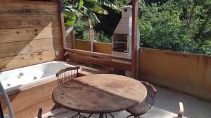 a table and chairs on a patio with a bath tub at Recem reformado, apartamento na Ferradurinha in Búzios