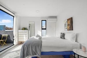 une chambre blanche avec un grand lit et une fenêtre dans l'établissement South Yarra Luxe - Spacious Townhouse & Parking, à Melbourne