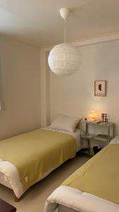 een slaapkamer met 2 bedden en een lamp bij Stay early mansion in Incheon