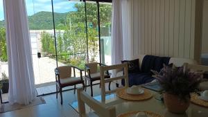 a living room with a table and chairs and a couch at Casa MonteFlor - Refúgio onde a vida desacelera com gentileza in Governador Celso Ramos