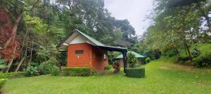 Ban Sop Mae KlangPloy&Praew House 2的前面有摩托车的草场上的小小屋