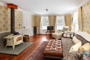 een woonkamer met een bank en een houtkachel bij The Tannery House in Claryville