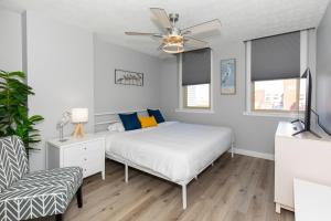 a white bedroom with a bed and a ceiling fan at NEW! Remodeled & Upgraded Vacation Apartment in Sandusky