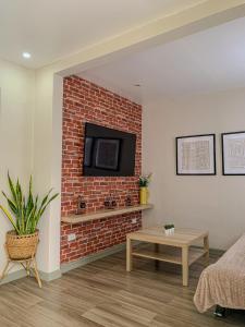 un soggiorno con camino in mattoni e TV di The Barkly House Staycation a Biñan