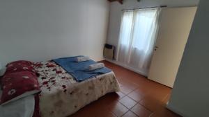 Un dormitorio pequeño con una cama y una ventana. en Dpto 1 dormitorio B, en Río Grande