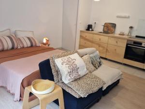 a bedroom with a bed and a couch and a table at Studio neuf avec terrasse au cœur de Le Palais - FR-1-418-260 in Le Palais