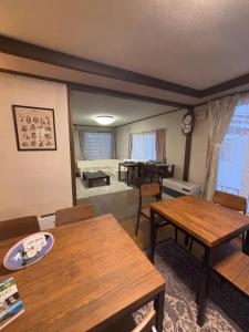 ein Wohnzimmer mit Tischen und ein Esszimmer in der Unterkunft シマエナガニセコ in Kutchan