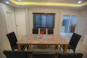 a dining room table with a vase of flowers on it at Pool Villa near Chiang Mai city with WiFi in Saraphi