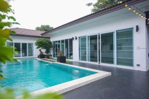 a swimming pool in front of a house at Pool Villa near Chiang Mai city with WiFi in Saraphi
